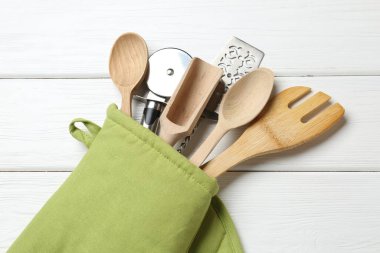 Farklı mutfak aletleri fırın eldiveni beyaz ahşap masa, üst görünüm