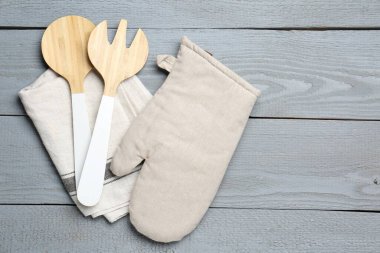 Mutfak gereçleri ve fırın eldiveni açık gri ahşap masa, üst manzara. Metin için boşluk