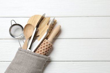 Fırın eldivenindeki farklı mutfak aletleri beyaz ahşap masa, üst manzara. Metin için boşluk
