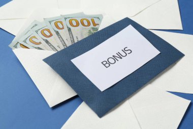 Zarflar kelime ikramiyesi ve para mavi arka planda, yakın plan