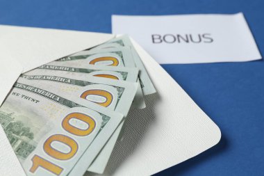 Mavi arka planda para ve kelime bonusu ile zarf, yakın plan