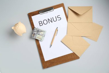 Kelime bonusu, zarf, para ve açık gri arka planda kumbara içeren pano, düz uzanma