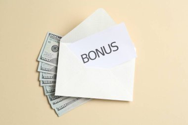 Kelime bonusu, zarf ve dolar banknotları bej arka planda, düz yatıyordu