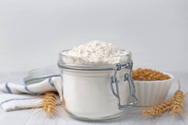 Buğday unu, tahıl ve çiviler beyaz fayanslı masada, yakın plan.