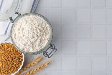 Buğday unu, tahıl ve çiviler beyaz fayanslı masada, düz yerde. Metin için boşluk