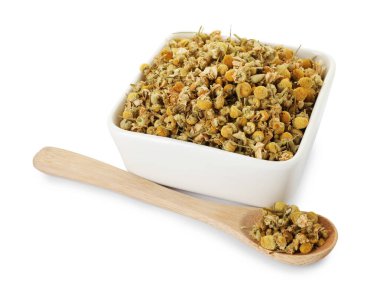 Kuru papatya çiçekleri kasede ve kaşıkla beyaza izole edilmiş.