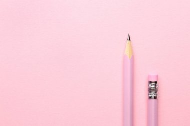 Pembe arka planda iki grafit kalem, düz. Metin için boşluk