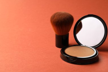 Aynalı açık yüz pudrası ve mercan zemin fırçası, yakın plan. Metin için boşluk
