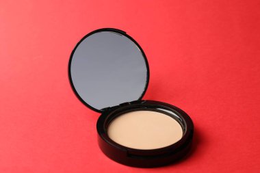 Kırmızı arkaplanda aynalı açık yüz pudrası, yakın plan