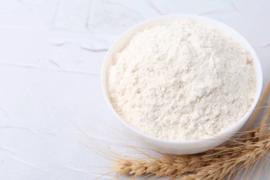 Buğday unu kasede ve çiviler beyaz masada, üst tarafta. Metin için boşluk