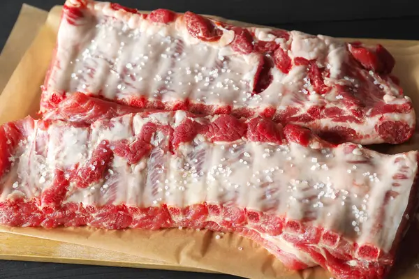 Çiğ domuz pirzolası ve deniz tuzu, yakın plan.