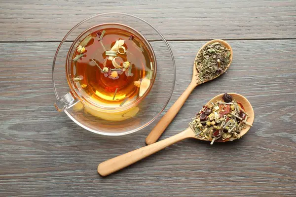 Cam bardakta Aromatik bitki çayı ve ahşap masada kuru yapraklar.