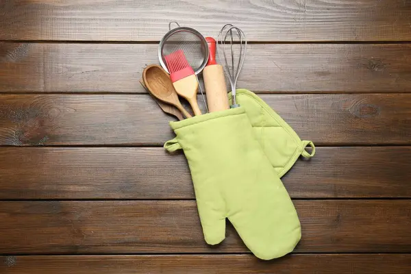 Farklı mutfak aletleri fırın eldiveni ahşap masa, üst görünüm