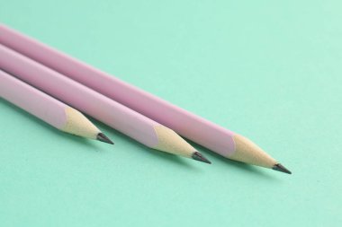 Turkuaz arka planda birçok grafit kalem, yakın plan