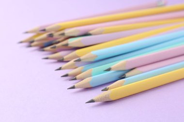 Menekşe arkaplan üzerinde birçok grafit kalem, yakın plan