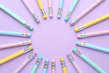 Mor arka planda silgisi olan birçok grafit kalemden yapılmış çerçeve düz yatıyordu. Metin için boşluk