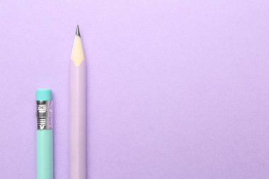 Menekşe arka planda iki grafit kalem, düz. Metin için boşluk