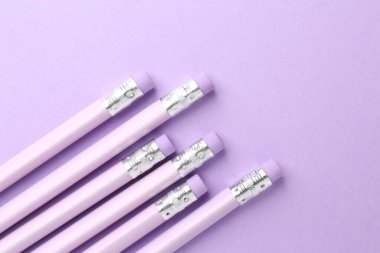 Menekşe arkaplanda silgisi olan bir sürü grafit kalem. Metin için boşluk