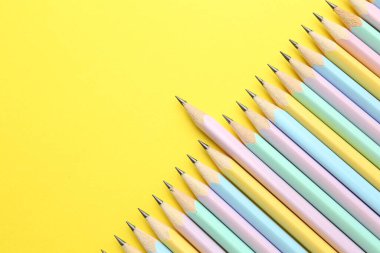 Sarı arka planda bir sürü grafit kalem var. Metin için boşluk