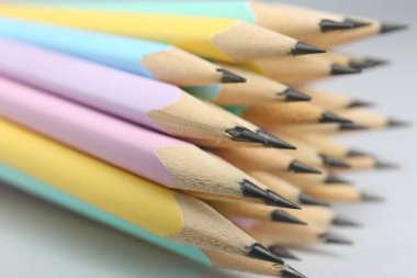 Açık gri arkaplanda birçok grafit kalem, yakın plan