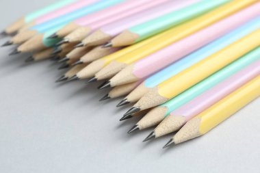 Açık gri arkaplanda birçok grafit kalem, yakın plan