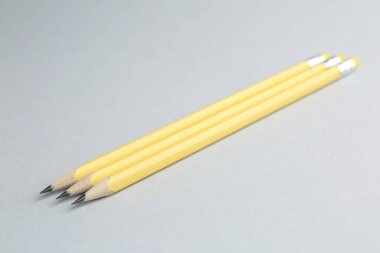 Açık gri arkaplanda birçok grafit kalem, yakın plan