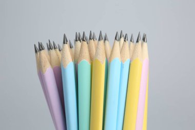 Açık gri arkaplanda birçok grafit kalem, yakın plan