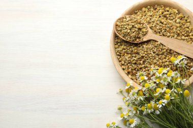 Kuru ve taze papatya çiçekleri açık ahşap masada, düz yerde. Metin için boşluk