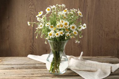 Tahta masadaki cam vazoda güzel papatya çiçekleri.