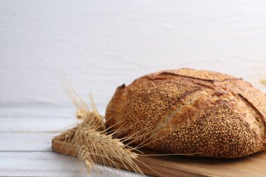 Taze ekmek ve çiviler beyaz ahşap masada, yakın plan. Metin için boşluk