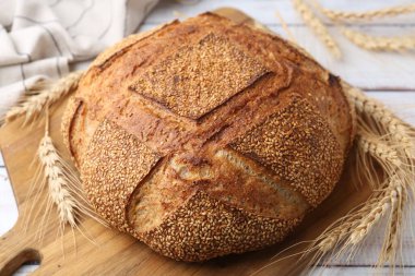 Taze ekmek ve çiviler beyaz ahşap masada, yakın plan.