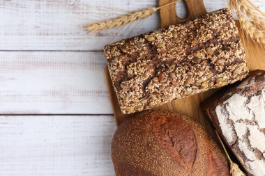 Taze ekmek somunları ve beyaz ahşap masada çiviler düz yerde. Metin için boşluk