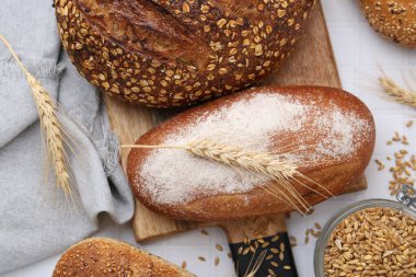 Taze ekmek somunları ve çiviler beyaz masada, düz yatıyordu.