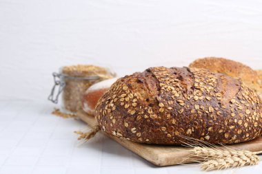 Taze ekmek somunları ve beyaz fayanslı masada çiviler. Metin için boşluk