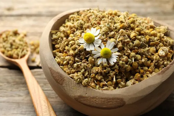 Kuru ve taze papatya çiçekleri kasede masada, yakın plan.