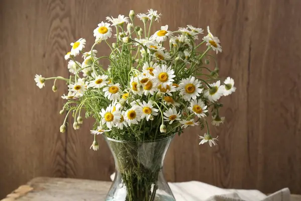 Güzel papatya çiçekleri cam vazoda, masada, yakın plan