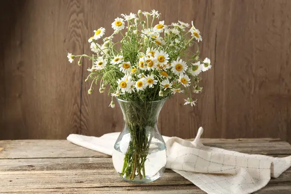 Tahta masadaki cam vazoda güzel papatya çiçekleri.