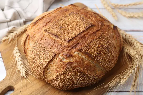 Taze ekmek ve çiviler beyaz ahşap masada, yakın plan.