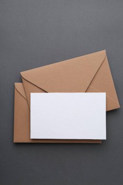Gri arkaplanda boş tebrik kartı ve zarflar, üst görünüm