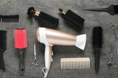 Gri dokulu arka planda farklı saç şekillendirme araçları, düz yatış