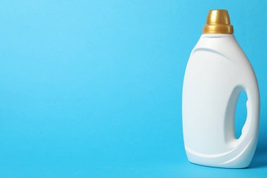 Açık mavi arkaplanda bir şişe yumuşatıcı, metin için boşluk