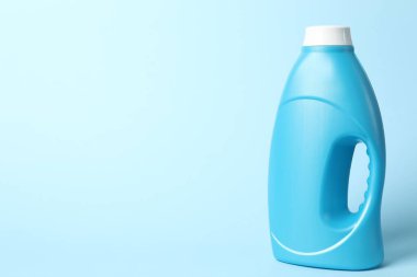 Açık mavi arkaplanda bir şişe yumuşatıcı, metin için boşluk