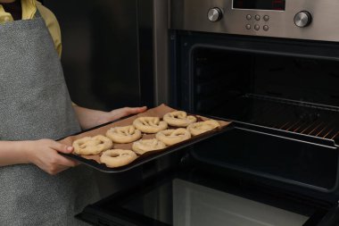 Pişmemiş krakerlerle fırına yemek koyan kadın, yakın plan.