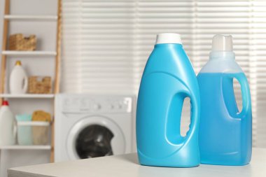 Ahşap masa üzerinde yumuşatıcı şişeler, metin için yer.