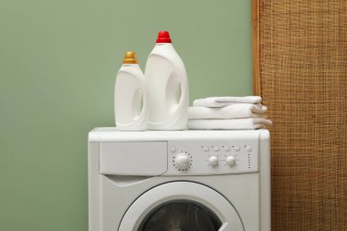 İçerideki çamaşır makinesinde yumuşatıcı ve havlu şişeleri.