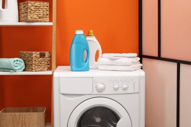 İçerideki çamaşır makinesinde yumuşatıcı ve havlu şişeleri.