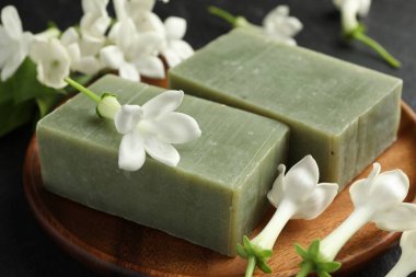 Siyah masada sabun ve yasemin çiçekleri, yakın plan.