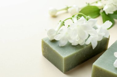 Bej arka planda sabun ve yasemin çiçekleri, yakın plan. Metin için boşluk