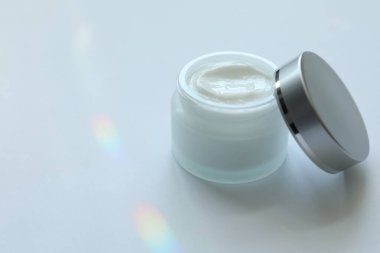 Beyaz arka planda bir kavanoz vücut kremi, yakın plan. Metin için boşluk