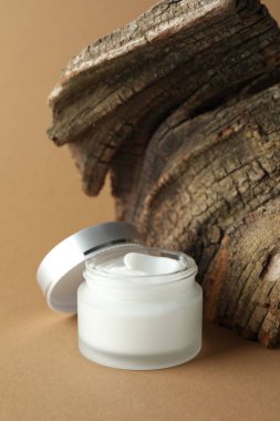 Bej arka planda bir kavanoz vücut kremi.